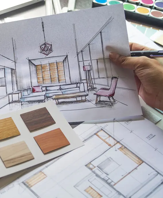 Architecte d’intérieur Cuisines ELITE dessinant un croquis avec échantillons de bois et plans