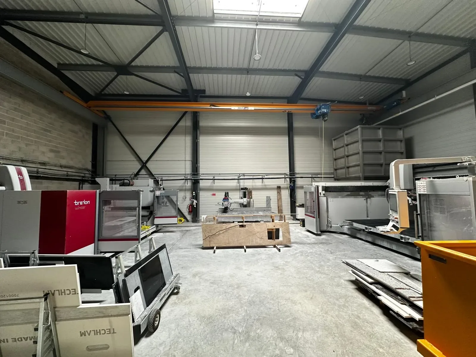 Atelier de marbrerie Cuisines ELITE Stone avec centres d’usinage Breton et pont roulant