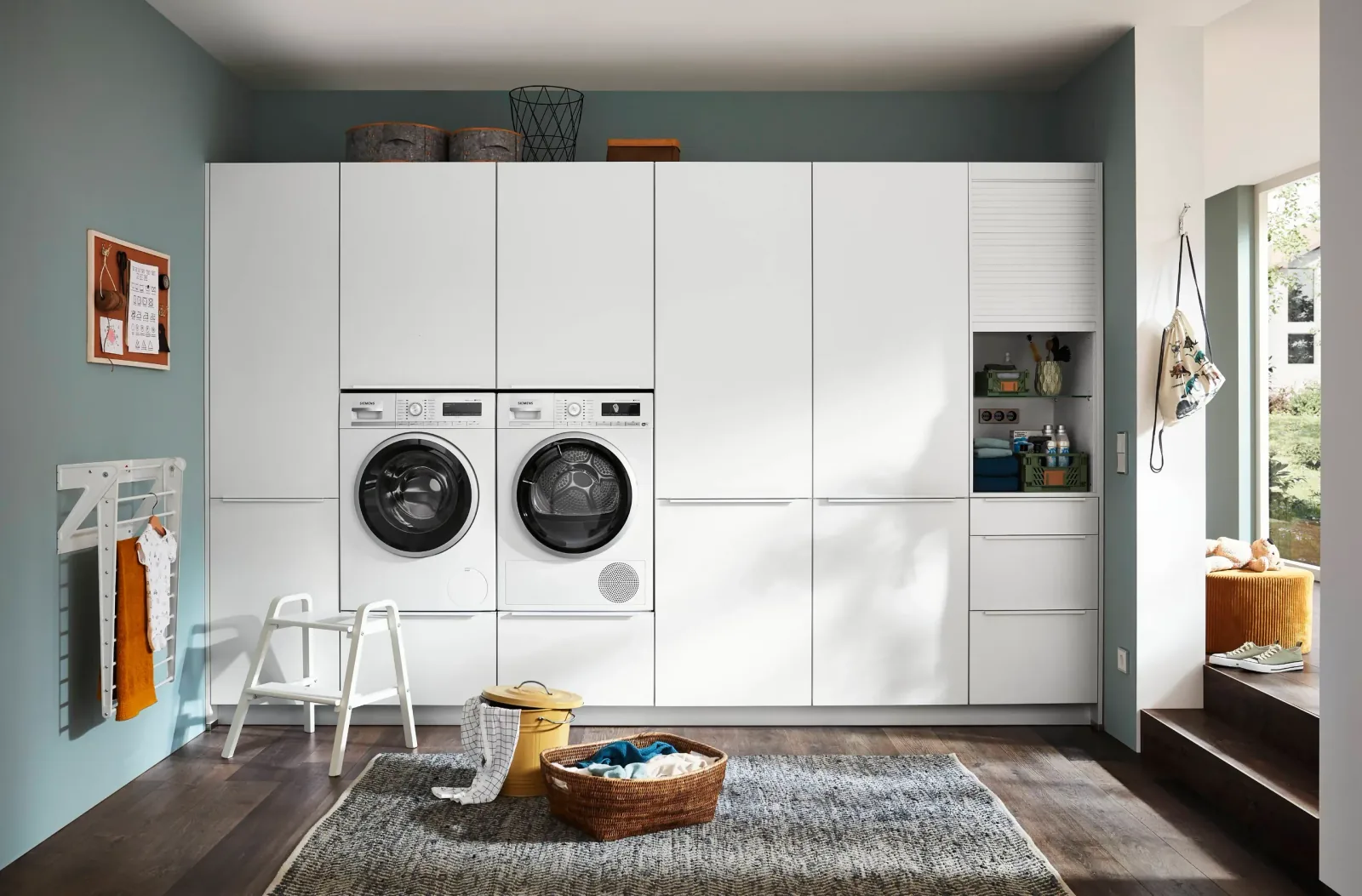 Buanderie blanche sur mesure avec colonnes de rangement, lave-linge et sèche-linge encastrés