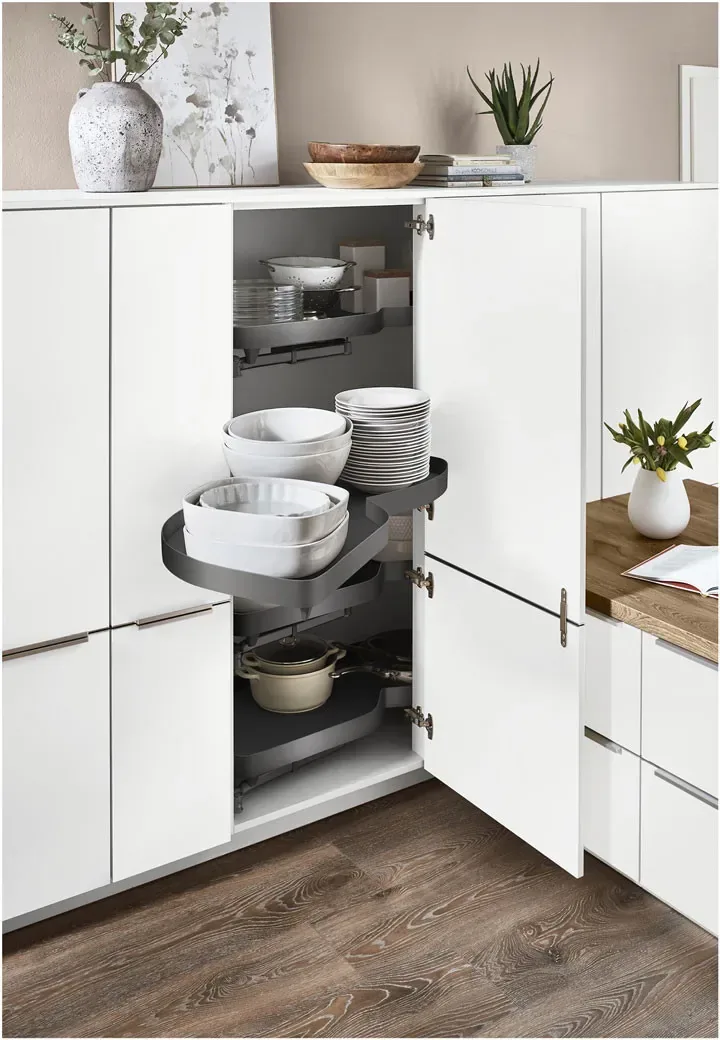 Colonne d’angle blanche avec plateaux tournants rangeant vaisselle et casseroles
