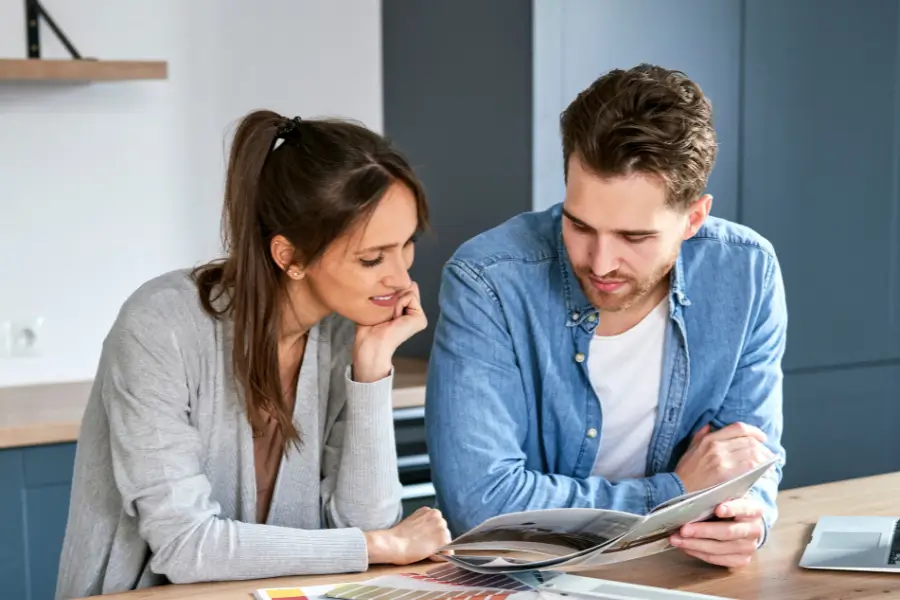 Couple consultant un catalogue pour leur projet cuisine