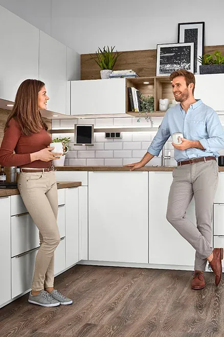 Couple discutant café à la main dans une cuisine blanche avec caissons XL et Maxi