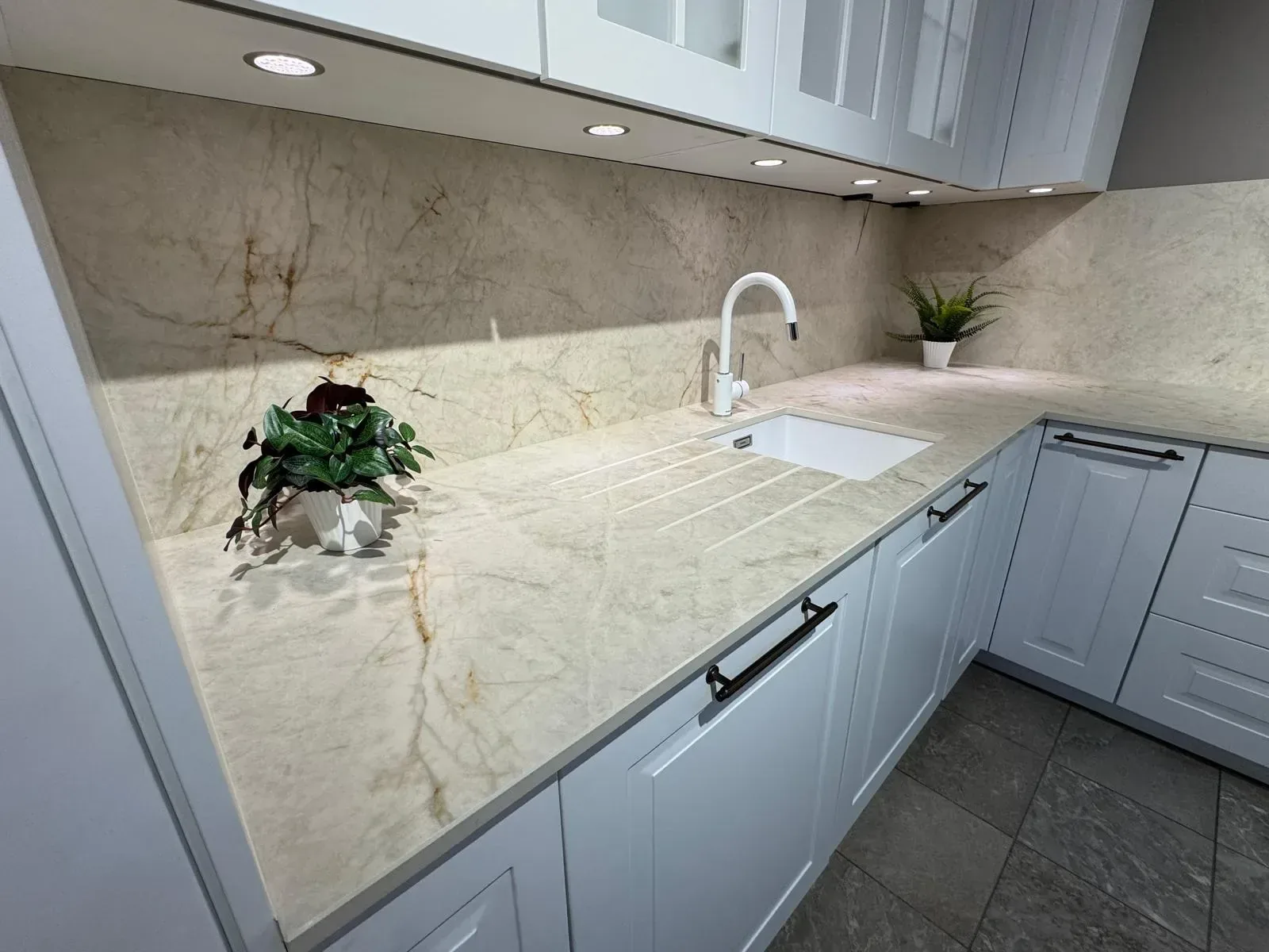 Cuisine blanche avec plan de travail et crédence assortie en pierre veinée beige
