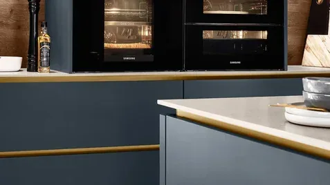 Cuisine teinte profonde bleu marine avec fours Samsung encastrés et finitions dorées