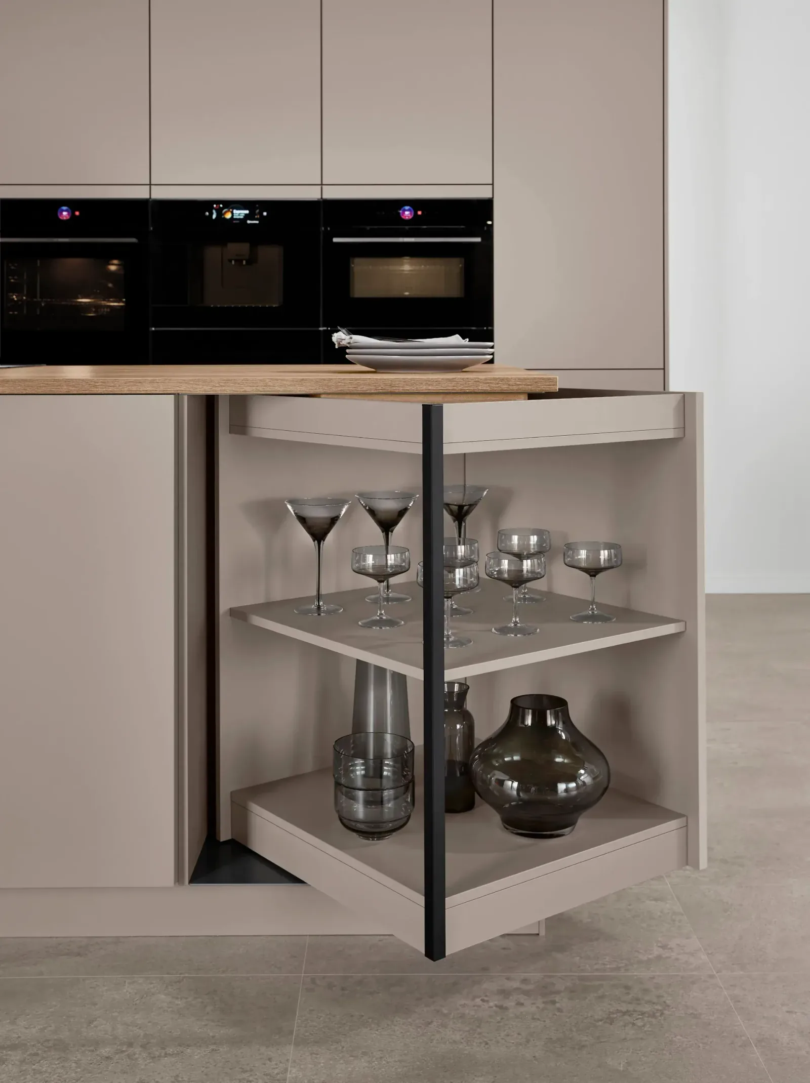 Cuisine équipée avec îlot central et rangement d’angle pivotant pour verrerie