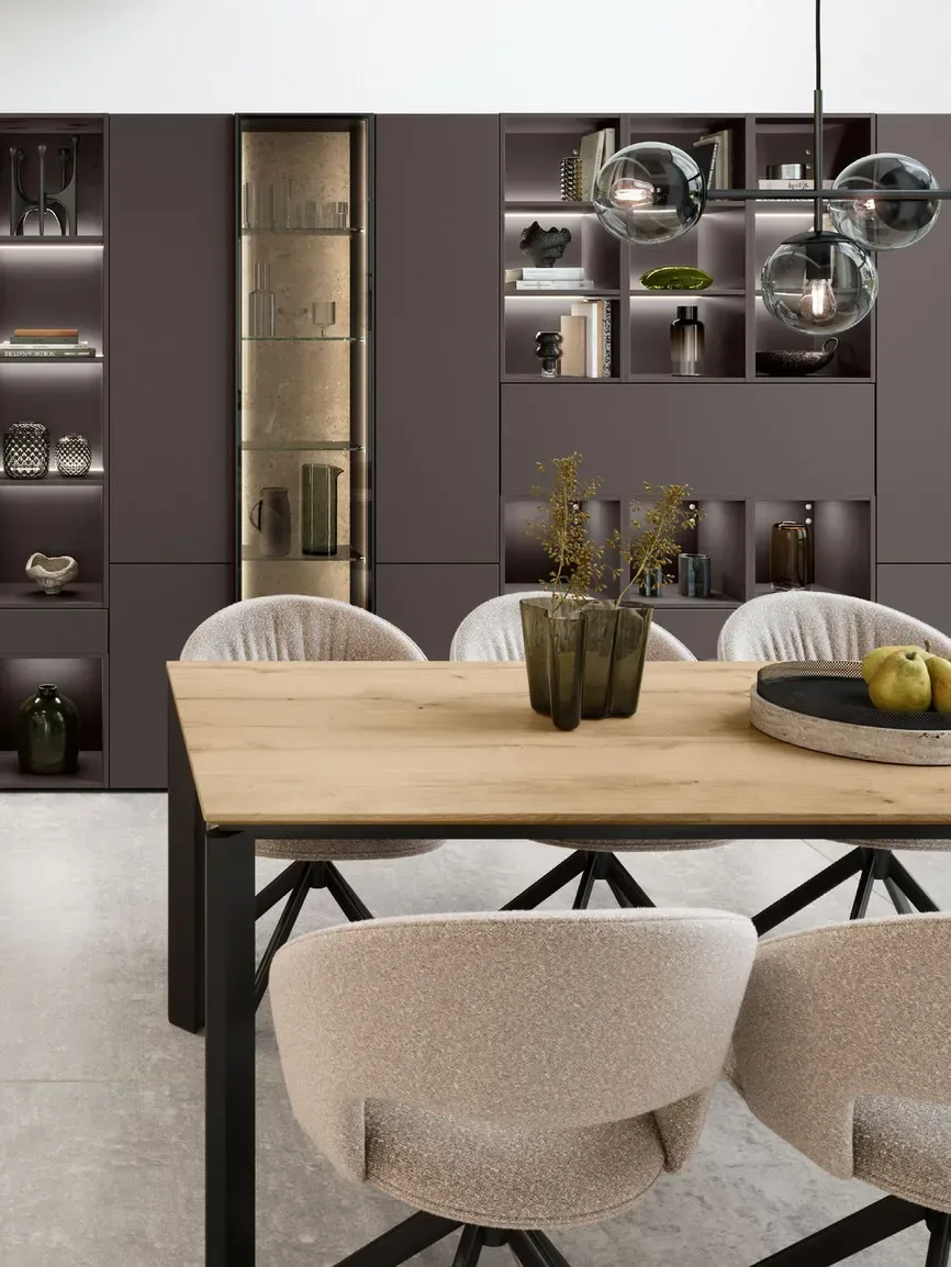 Mur bibliothèque optimisé marron avec niches éclairées, table à manger bois et chaises bouclé beige