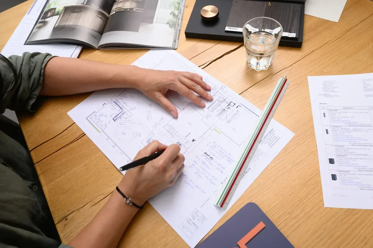 Concepteur dessinant à la main le plan d’implantation d’une cuisine sur mesure