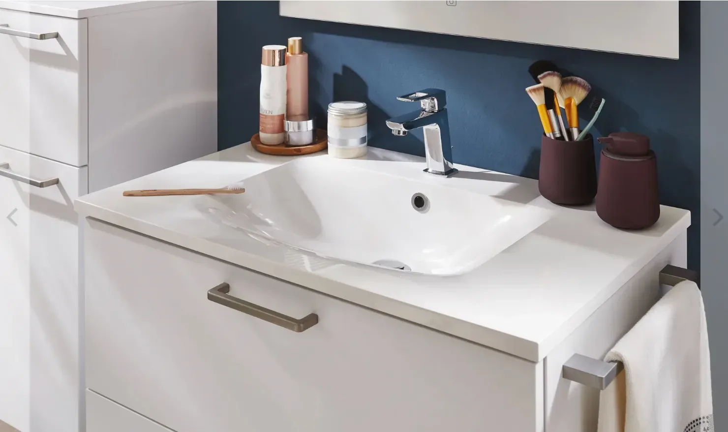 Vasque blanche encastrée sur meuble sous vasque, mitigeur chromé et accessoires de salle de bain