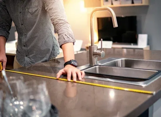 Technicien prenant les mesures d’un plan de travail pour une cuisine sur mesure