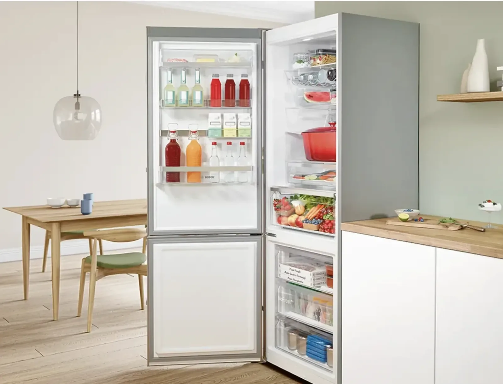 Réfrigérateur combiné Bosch ouvert, rempli d’aliments et de boissons, dans une cuisine ouverte