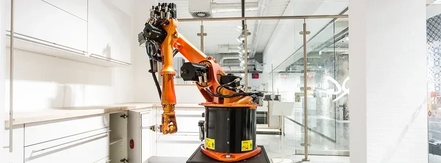Bras robotisé testant la durée de vie et la résistance des meubles de cuisine en laboratoire