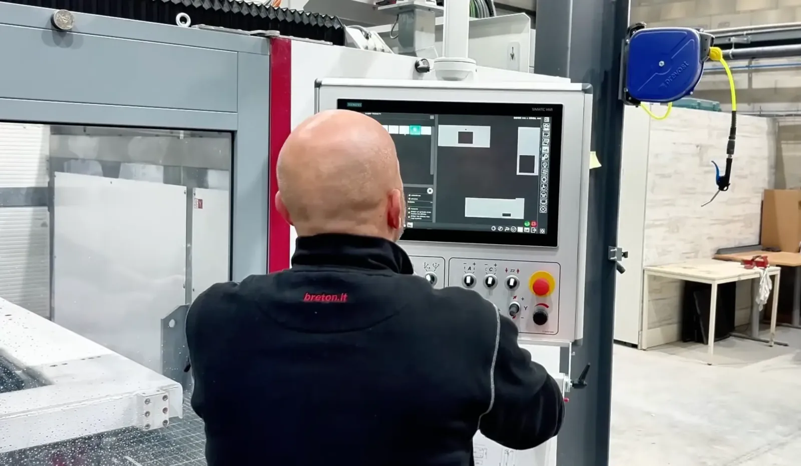 Technicien Breton programmant le centre d’usinage numérique dans l’atelier de marbrerie